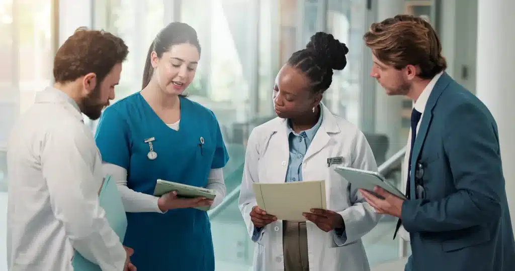 Businessman, doctors and nurse with tablet in clinic for medical admin