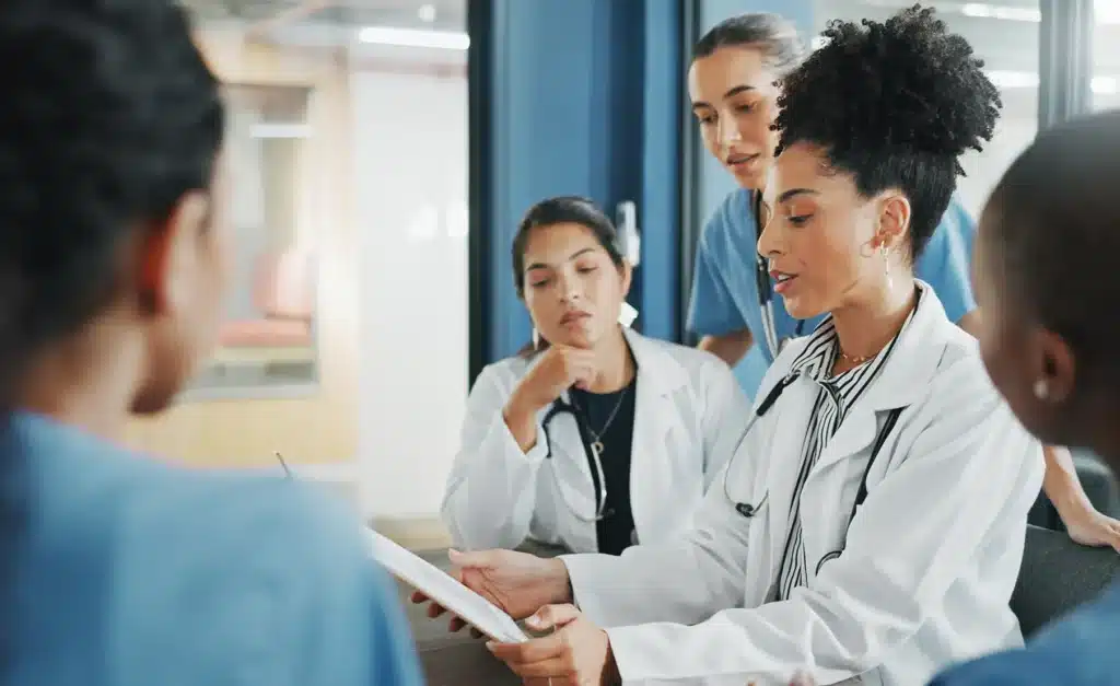 Doctors, nurse and women on clipboard in meeting, collaboration